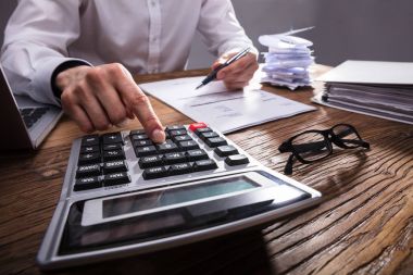İşadamı'nın el ahşap masa hesap makinesiyle Bill hesaplama