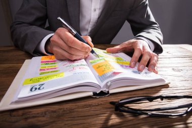 İşadamı'nın el yazma programı Diary ahşap masa üzerine kalem ile