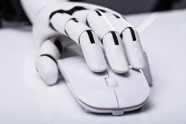 Close-up Of A Robotic Hand Using Computer Mouse