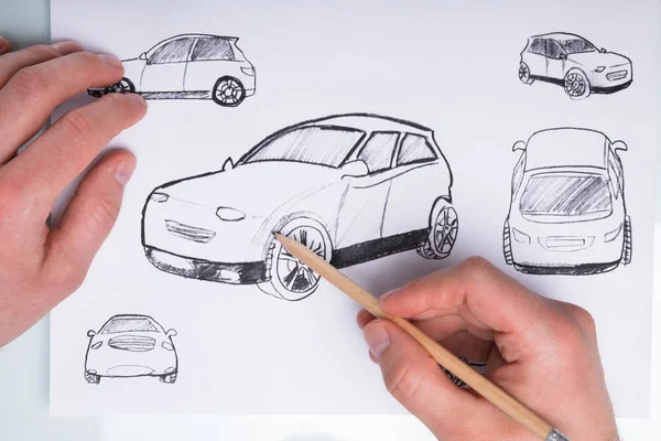 Human Hand Drawing Sketch Of A Car With Pencil On Paper