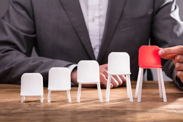 Menselijke Hand Rode Stoel Onder Witte Stoelen Een Rij Kiezen — Stockfoto