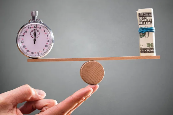 Una Mano Persona Con Equilibrio Entre Cronómetro Billetes Enrollados Balancín — Foto de Stock