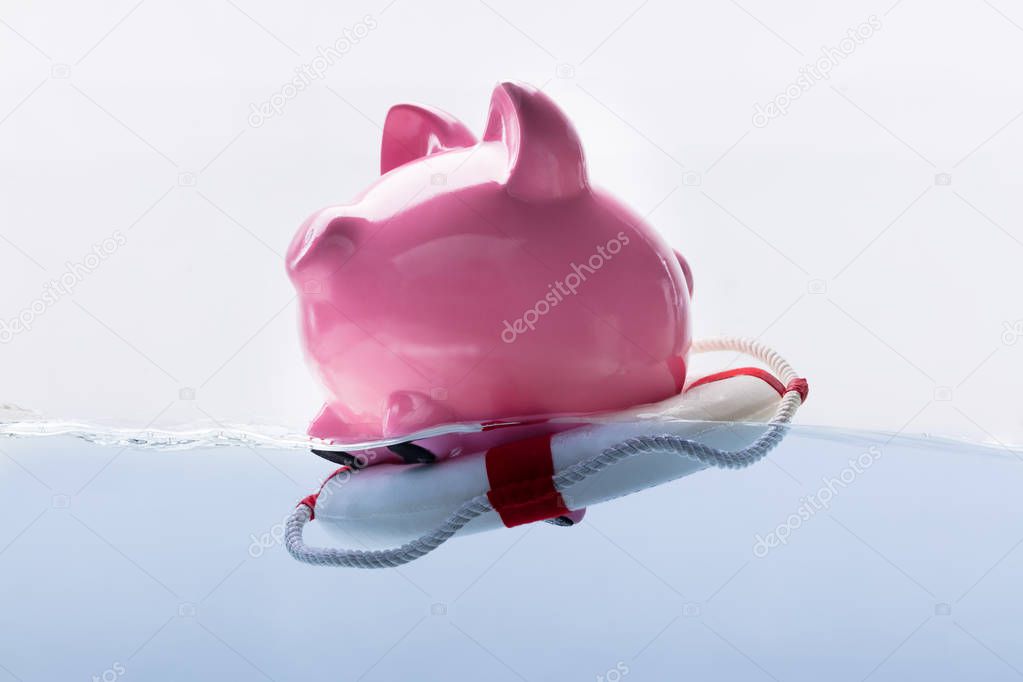 Close-up Of A Pink Piggy Bank Floating On Lifebuoy