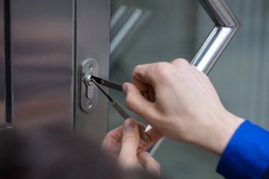 Close-up Of A Person's Hand Opening Door With Lockpicker clipart