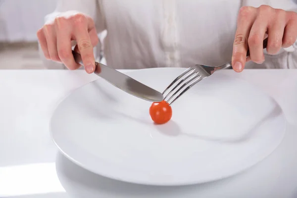 Person Hand Cutting Cherry Tomato Plate Knife Fork — Stock Photo, Image