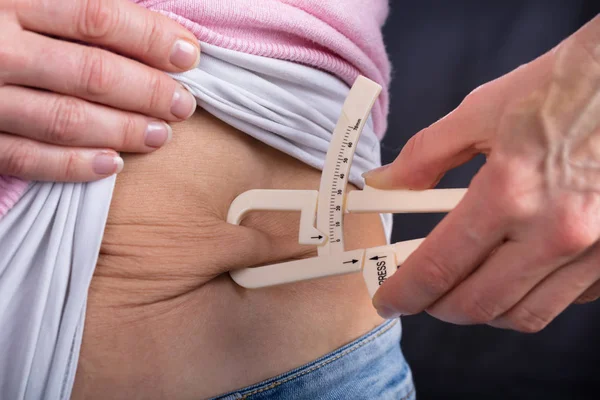 Close Van Een Vrouw Hand Meten Van Maag Vet Met — Stockfoto