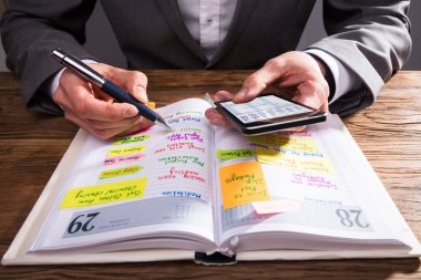 İşadamı'nın el yazma programı Diary ahşap masa üzerine kalem ile