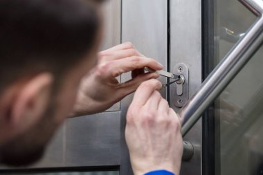 Close-up Of A Young Man Opening Door With Lockpicker clipart