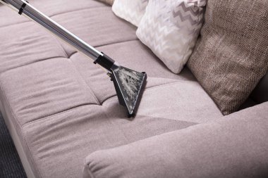 Kirli kanepe evde elektrikli süpürge, yüksek açılı görünüş