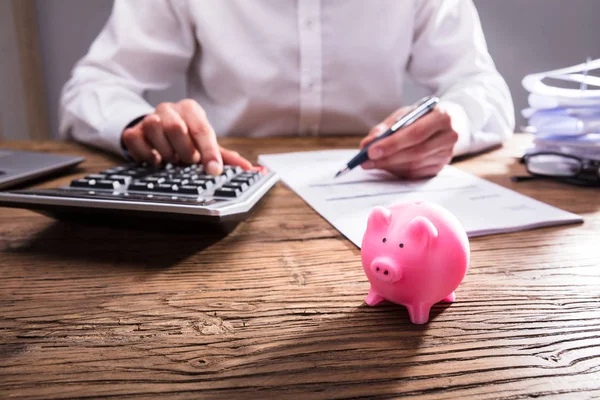 Ondernemer Berekening Van Bill Met Kleine Spaarpot Houten Bureau — Stockfoto