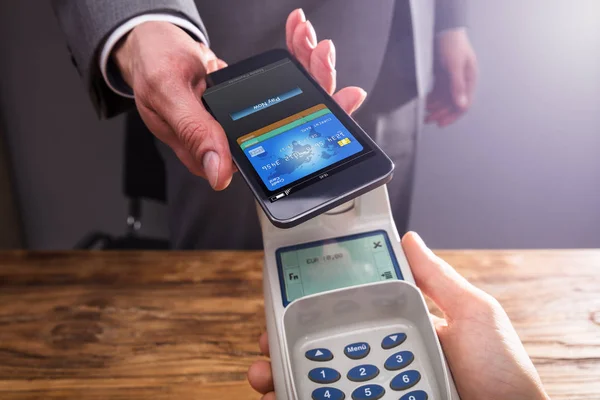 Close Businessperson Hand Paying Smartphone Using Nfc Technology Wooden Desk — Stock Photo, Image