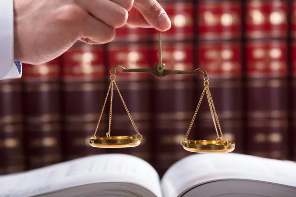 Суддя Тримає Шкалу Справедливості Перед Юридичною Книгою — стокове фото