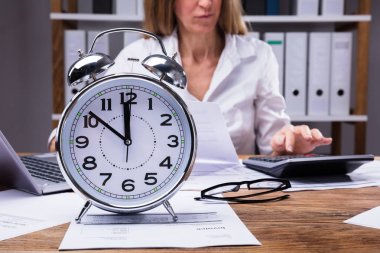 Bir çalar saat çalışma Office işkadını önünde faturadaki Close-Up