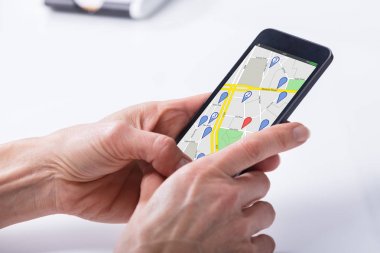 Bir kişinin el Gps navigasyon haritası üstünde hareket eden telefon kullanarak Close-Up