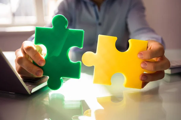 Close Mão Empresário Segurando Dois Quebra Cabeça Branco Sobre Mesa — Fotografia de Stock