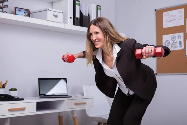 Lächelnde Reife Geschäftsfrau Beim Training Mit Roter Hantel Büro — Stockfoto