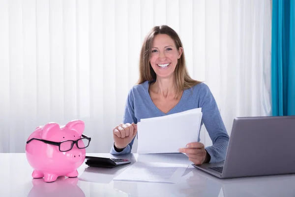 Mogen Glad Affärskvinna Beräkning Fakturan Med Miniräknare Med Piggybank Skrivbord — Stockfoto