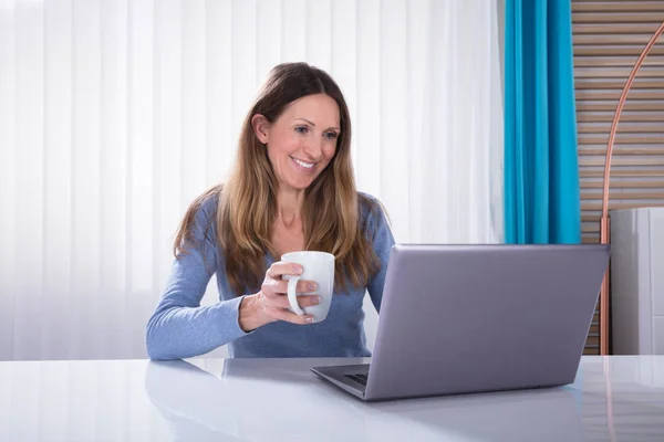 Close Mulher Feliz Segurando Xícara Café Olhando Para Laptop Mesa — Fotografia de Stock