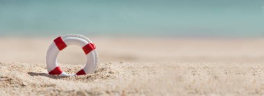 Panoramic View Of Single Lifebuoy On Sand At Beach clipart
