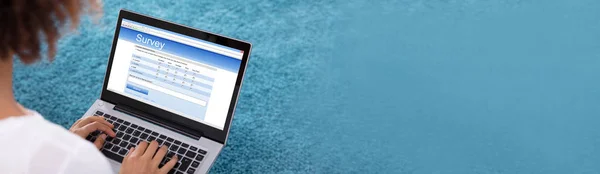 青色の背景を持つデジタルタブレット上の女性充填調査フォームのクローズアップ — ストック写真