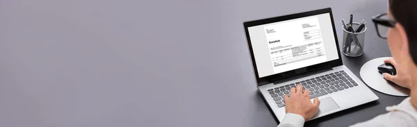 グレーの背景で請求書を準備するデジタルノートパソコンを使用しているビジネスマンのクローズアップ — ストック写真