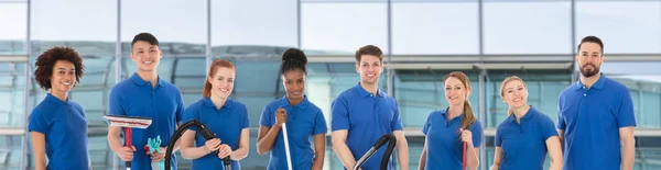 Retrato Sorridente Jovens Janitores Diversos Com Equipamento Limpeza Contra Vidro — Fotografia de Stock