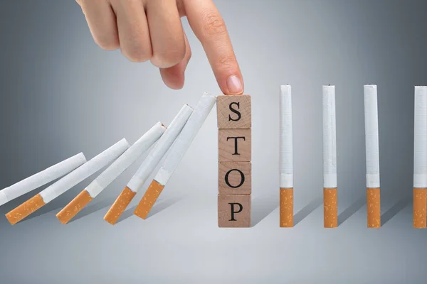 Person Finger Stopping Cigarette Falling Wooden Stop Blocks Gray Background — Stock Photo, Image