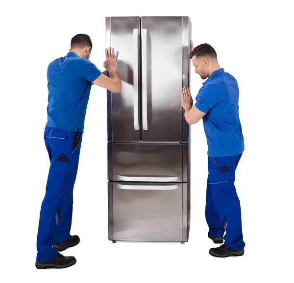 Rear View Two Male Movers Placing Sliver Refrigerator White Background — Stock Photo, Image