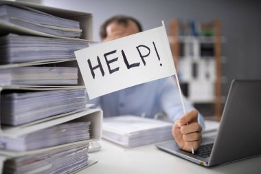 Dosyaların arasında el ele tutuşan bir iş adamının yakın plan fotoğrafı var.