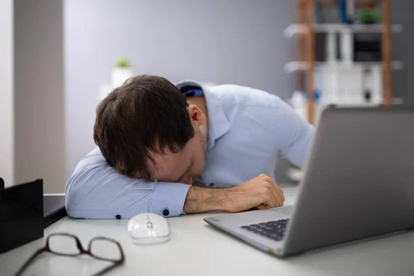 オフィスのデスクでノート パソコンが眠っていると青年実業家 — ストック写真
