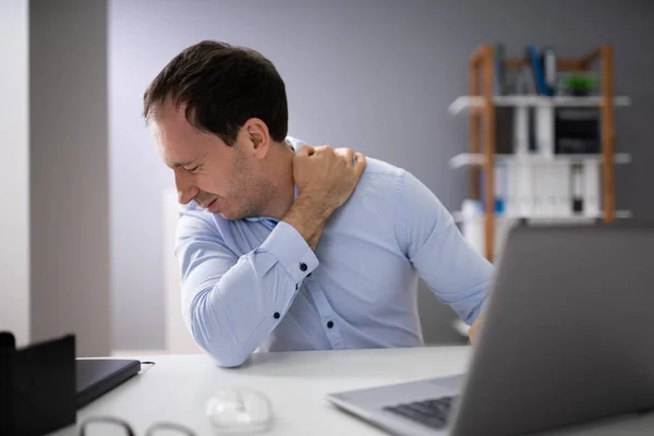 年轻人在笔记本电脑上工作时感到脖子痛 — 图库照片