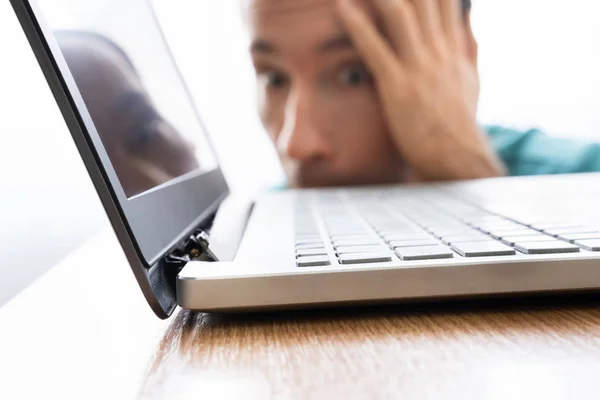 Man Looking At Damaged Laptop Computer With Broken Screen Attachment