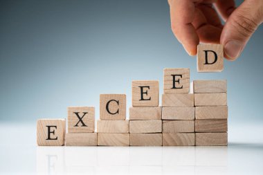 Kişi Elleri Üst üste tahta blokların üzerine Uzatılmış Metin Yerleştiriyor