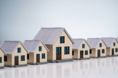 Yansıtıcı Masa Üzerinde Standart Konsepti Gösteren Minyatür Evler Satırı