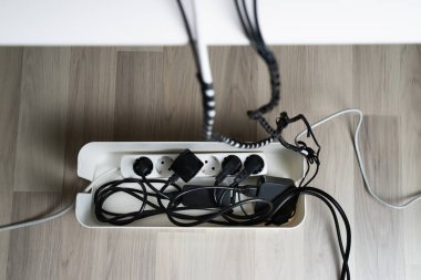High Angle View Of Cable Management Box With Cables On Hardwood Floor clipart