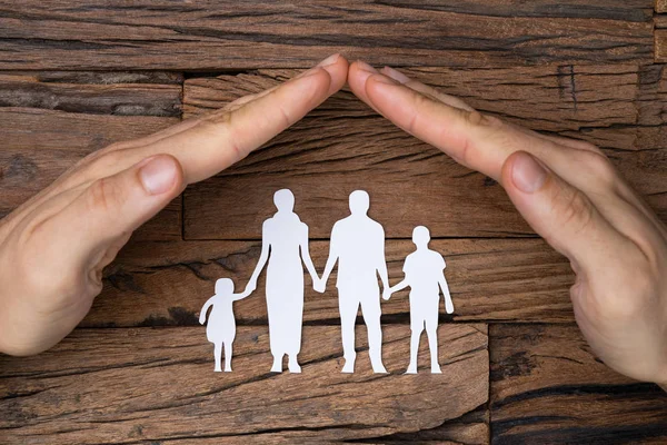 Close Man Hand Protecting White Cutout Family Paper Textured Wooden — Stockfoto