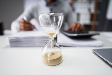 Kum saati ofisinde çalışan işadamının önünde Close-Up