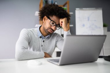 Üzgün genç adam masada dizüstü bilgisayarda çalışma