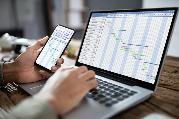Närbild Näringsidkares Hand Använda Smartphone Stund Analysera Gantt Diagram Laptop — Stockfoto