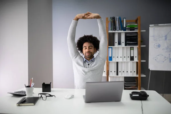 Jovem Empresário Esticando Seus Braços Com Laptop Mesa — Fotografia de Stock