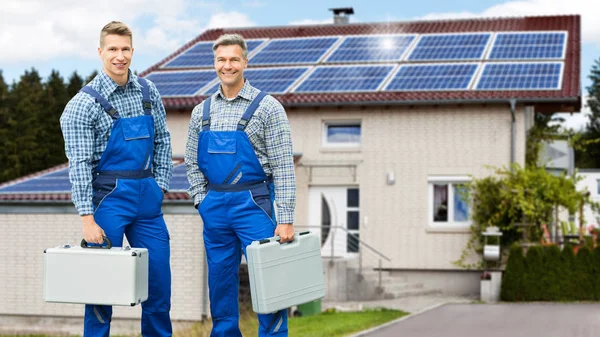 Portret Van Lachende Elektriciens Met Gereedschapskisten Voor Huis Met Zonnepaneel — Stockfoto