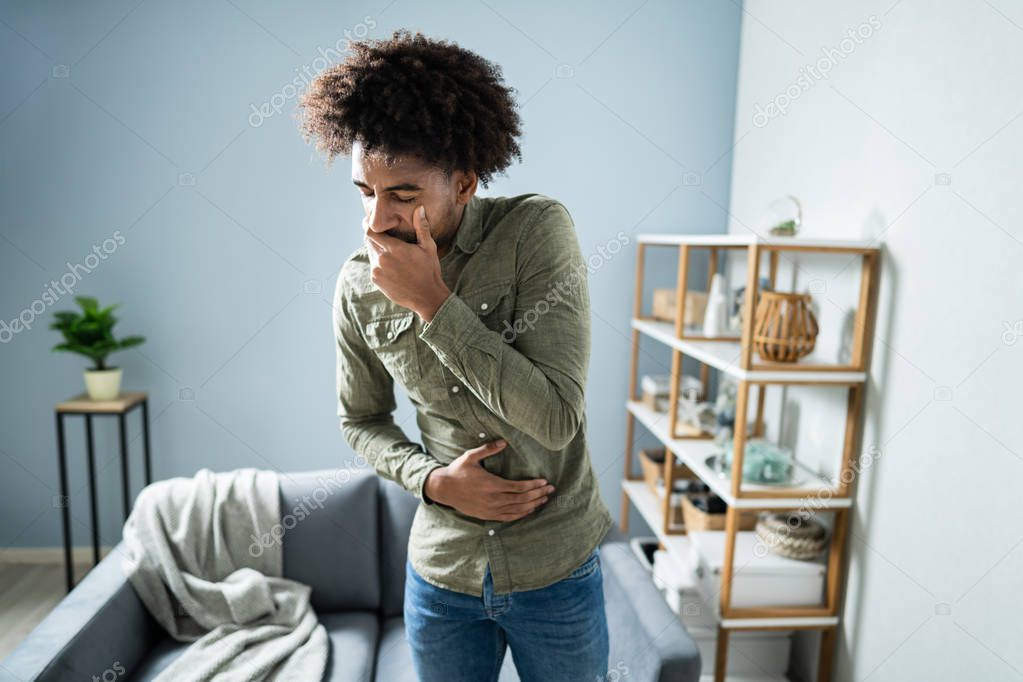 Young Man Suffering From Nausea At Home