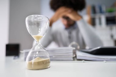 Kum saati ofisinde çalışan işadamının önünde Close-Up