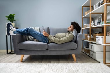 Dijital Tablet Kullanan Adam Koltukta Yatıyor