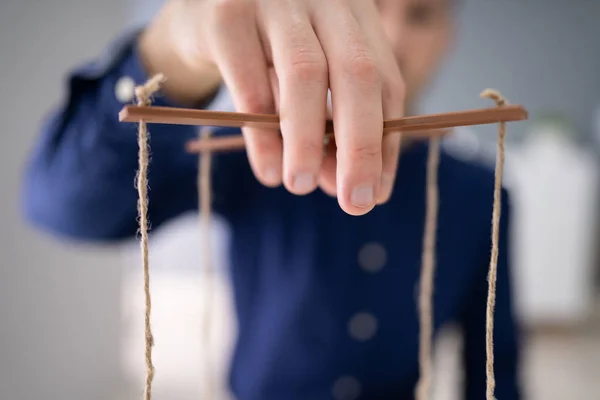一个商人的手用绳子操纵木偶的特写 — 图库照片