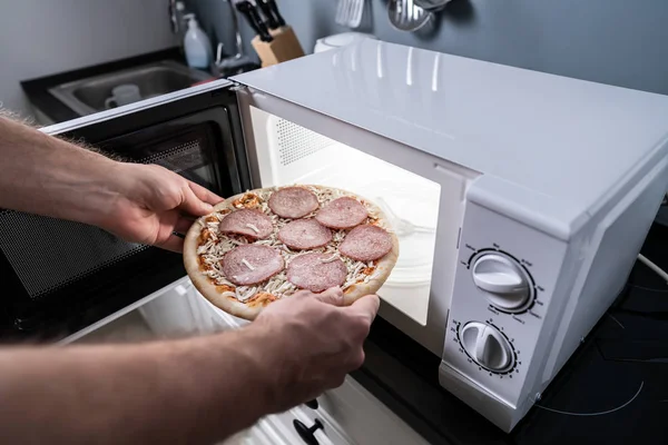Ανθρώπινο Χέρι Ψήσιμο Πίτσα Στο Φούρνο Μικροκυμάτων — Φωτογραφία Αρχείου