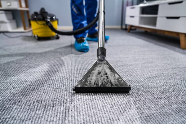 清洁工用吸尘器清洗地毯的照片 — 图库照片
