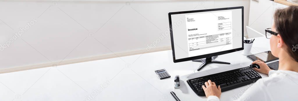 Close-up Of A Businesswoman Using The Computer With Invoice Form On Screen