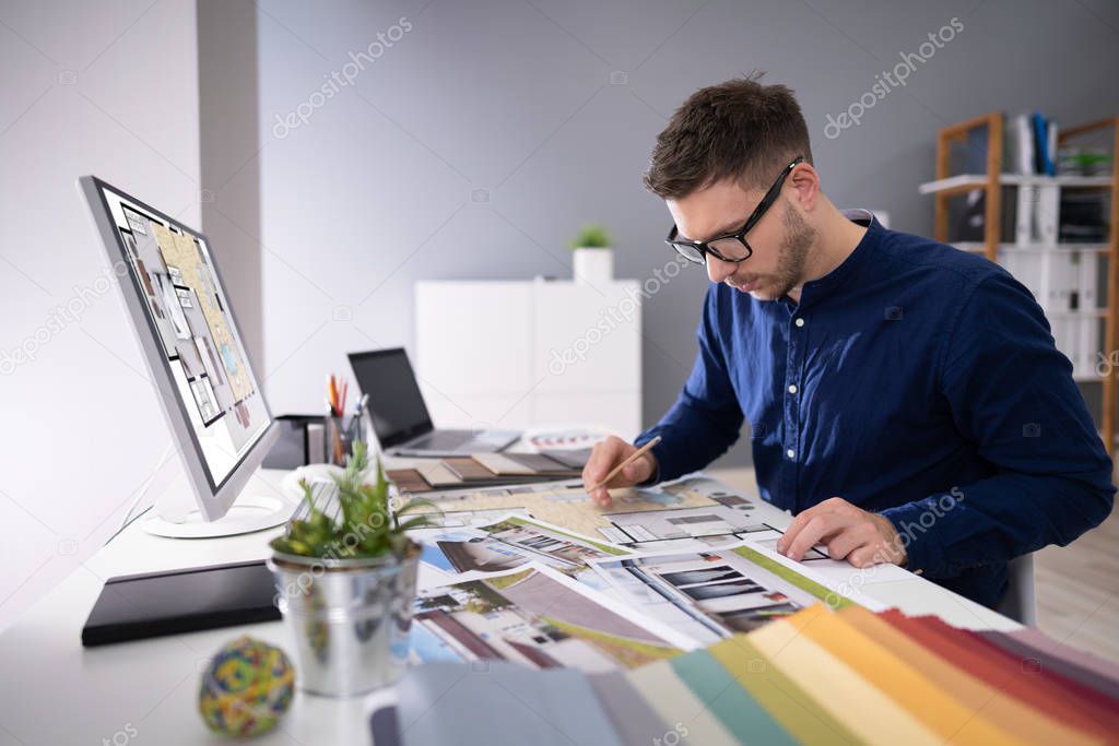 Side View Of Real Estate Designer Working On Computer In Office