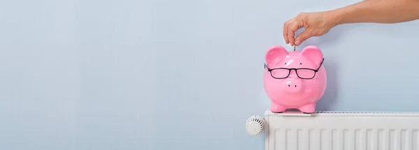 Persona Insertando Moneda Piggybank Sobre Radiador Casa — Foto de Stock